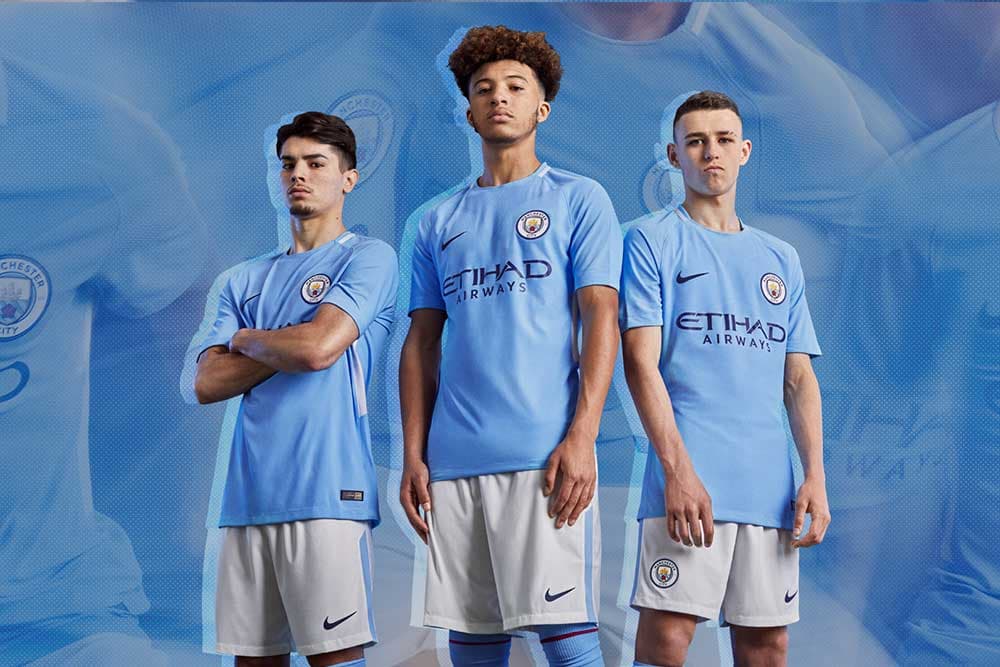 Brahim Diaz, Jadon Sancho and Phil Foden in the 2017-18 Manchester City Home Kit.