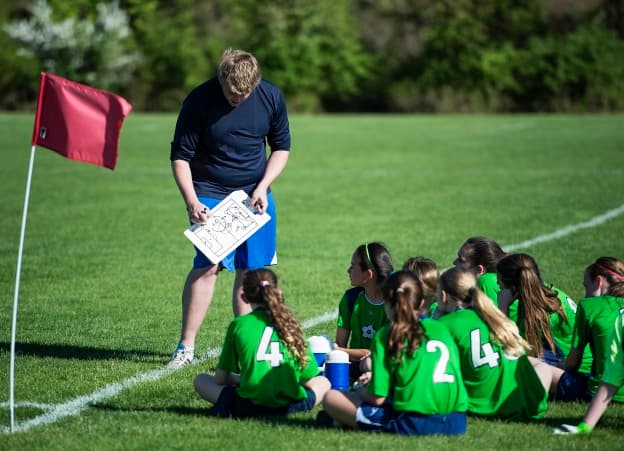 Coach instructs players during halftime of youth girls