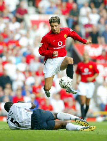 Manchester United's Cristiano Ronaldo (top) jumps over a tackle from Bruno N'Gotty of Bolton Wanderers during the first Premiership match of the season at Old Trafford in Manchester 16 August 2003. Ronaldo, making his debut, won a penalty and played sensationally after coming on as a substitute. Manchester United won the game 4-0. AFP PHOTO Adrian DENNIS (Photo credit should read ADRIAN DENNIS/AFP/Getty Images)