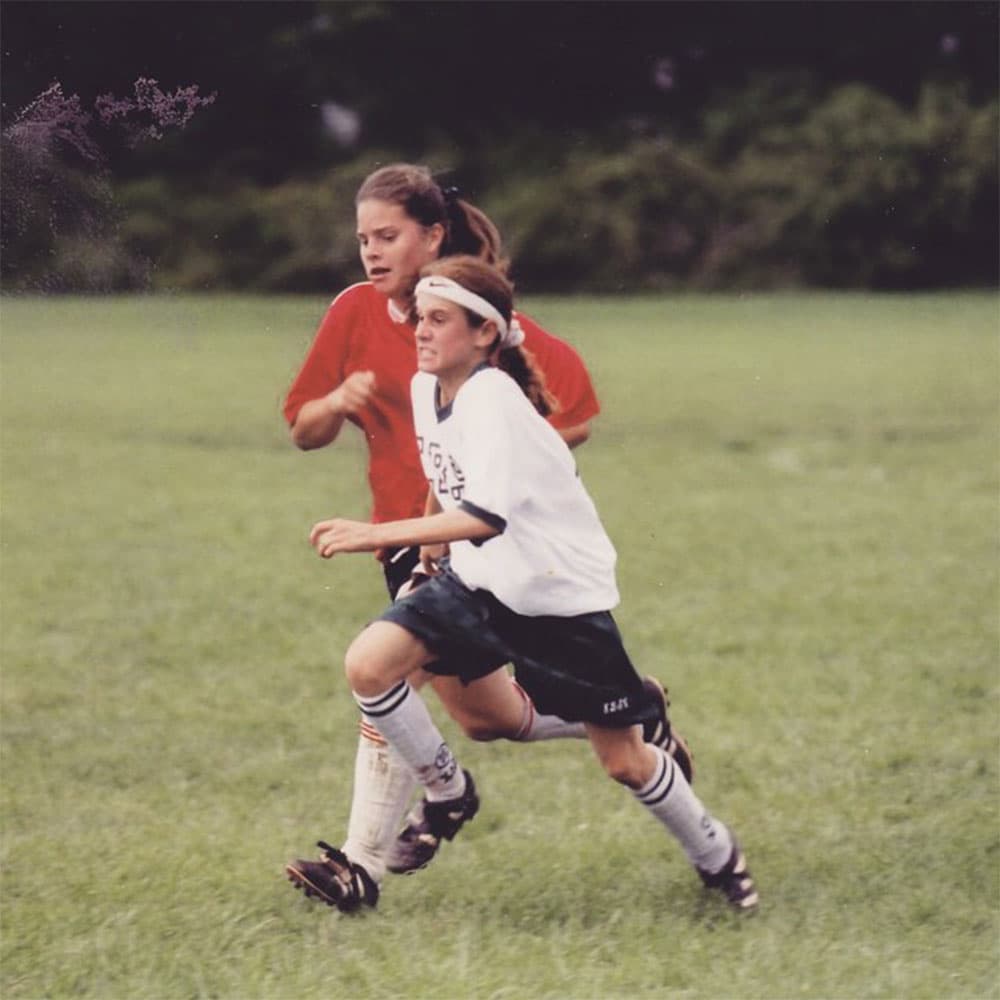A young Heather O'Reilly chases down a soccer ball.