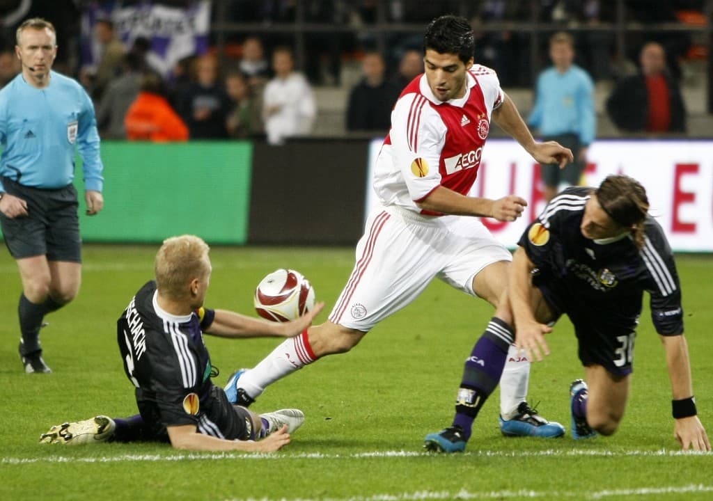 Ajax player Luis Suarez (C) duels for th