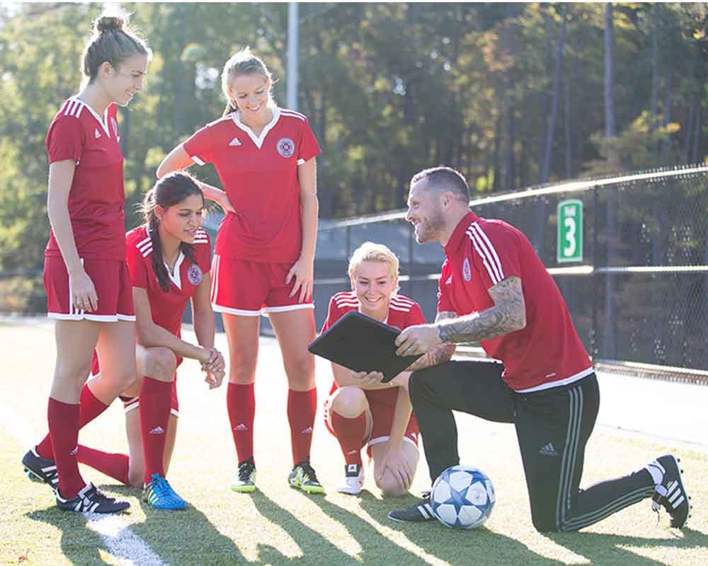 Soccer players and coach huddle